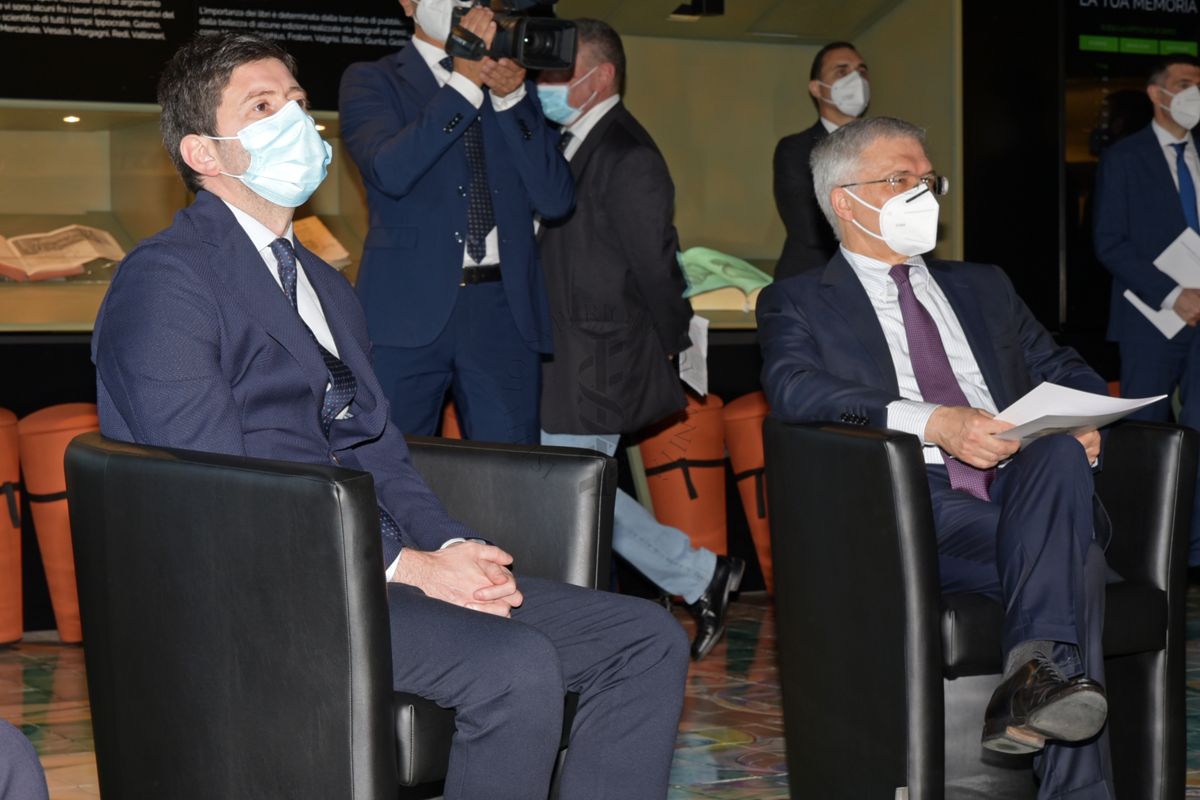Il Ministro della Salute Roberto Speranza (seduto, a sinistra) e il Ministro dell'Economia Daniele Franco (a destra) ascoltano l'intervento del Presidente Silvio Brusaferro