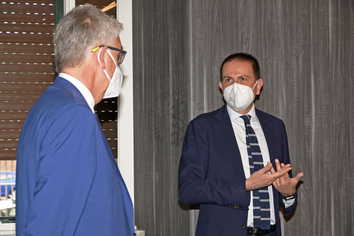 Il Prof. Silvio Brusaferro, Presidente dell'ISS (a sinistra) e l'Avv. Pierfrancesco De Rossi, Amministratore Delegato ad Interim di Siemens Italia (a destra) conversano della Sala Crisi dell'ISS