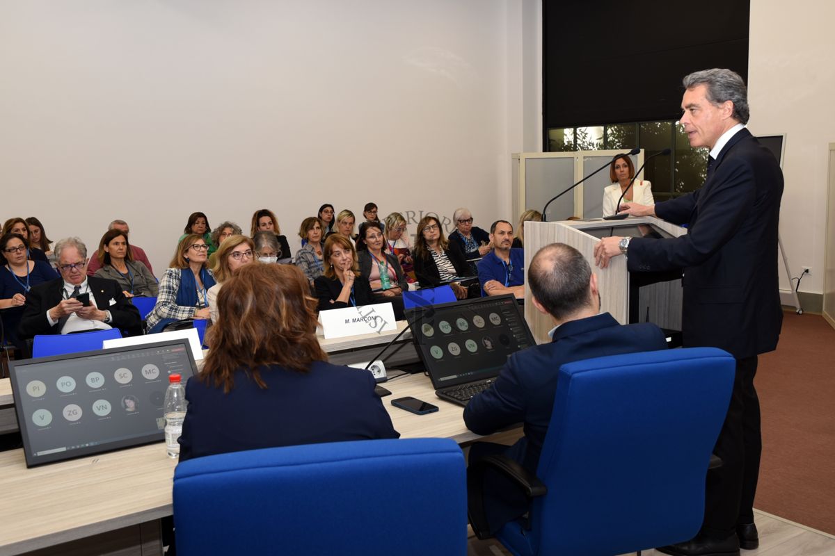 Intervento del Dott. Massimiliano Maselli, Assessore Servizi Sociali, Disabilità, Terzo Settore, Servizi alla Persona della Regione Lazio (a destra). Al centro, di spalle, il Dott. Matteo Marconi del Centro di Riferimento per la Medicina di Genere dell'Istituto Superiore di Sanità e a sinistra, di spalle la Dott.ssa Marina Petrini del Centro di Riferimento per la Medicina di Genere dell'Istituto Superiore di Sanità. In prima fila la Dott.ssa Gemma Calamandrei, Direttrice del Centro di RIferimento per le Scienze Comportamentali e la Salute Mentale dell'Istituto Superiore di Sanità (prima da sinistra) e la Dott.ssa Elena Ortona del Centro di Riferimento per la Medicina di Genere dell'Istituto Superiore di Sanità (seconda da sinistra)