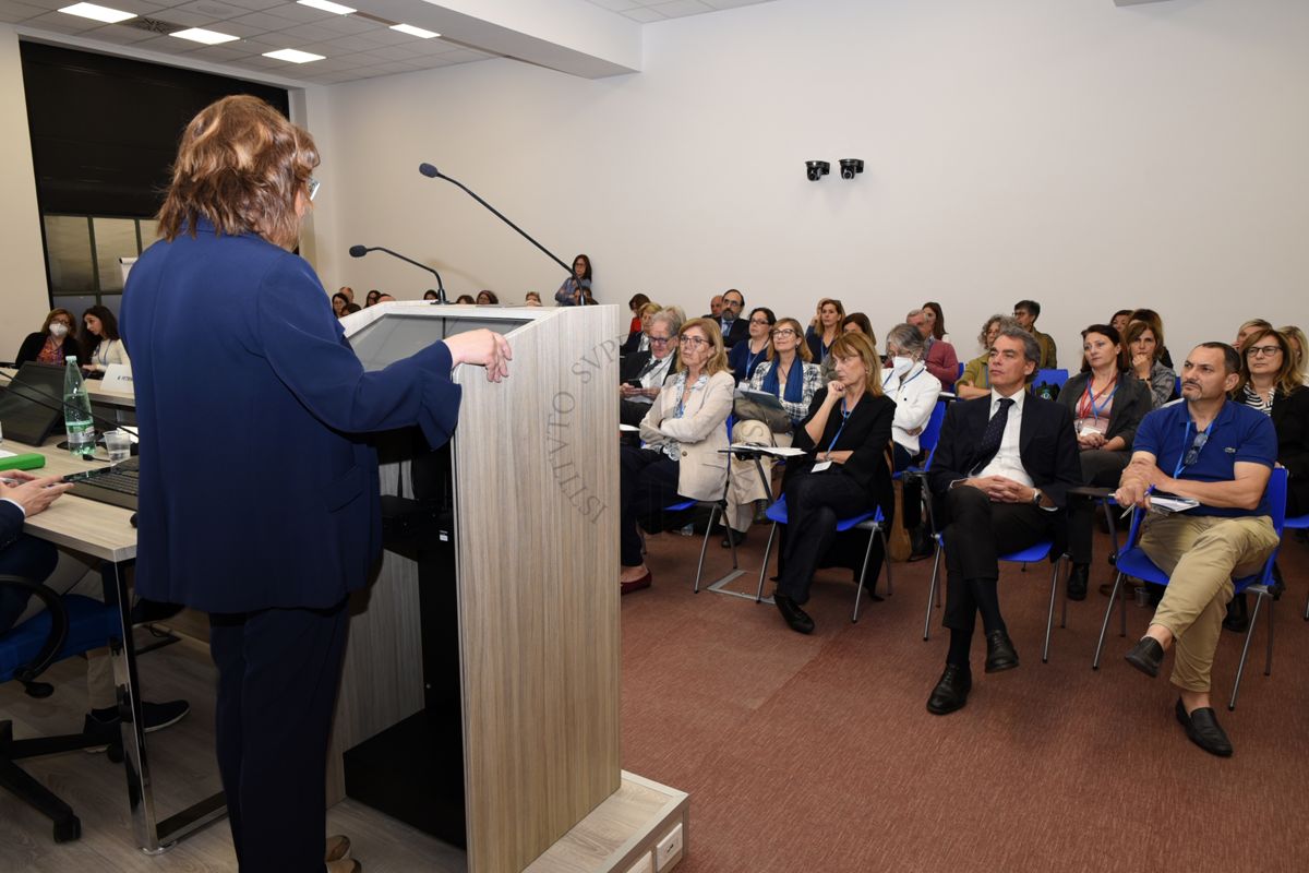 Intervento della Dott.ssa Marina Petrini del Centro di Riferimento per la Medicina di Genere dell'Istituto Superiore di Sanità (di spalle). In prima fila la Dott.ssa Gemma Calamandrei, Direttrice del Centro di RIferimento per le Scienze Comportamentali dell'Istituto Superiore di Sanità (prima da sinistra), la Dott.ssa Elena Ortona del Centro di Riferimento per la Medicina di Genere dell'Istituto Superiore di Sanità (seconda da sinistra) e il Dott. Massimiliano Maselli, Assessore Servizi Sociali, Disabilità, Terzo Settore, Servizi alla Persona della Regione Lazio (terzo da sinistra)