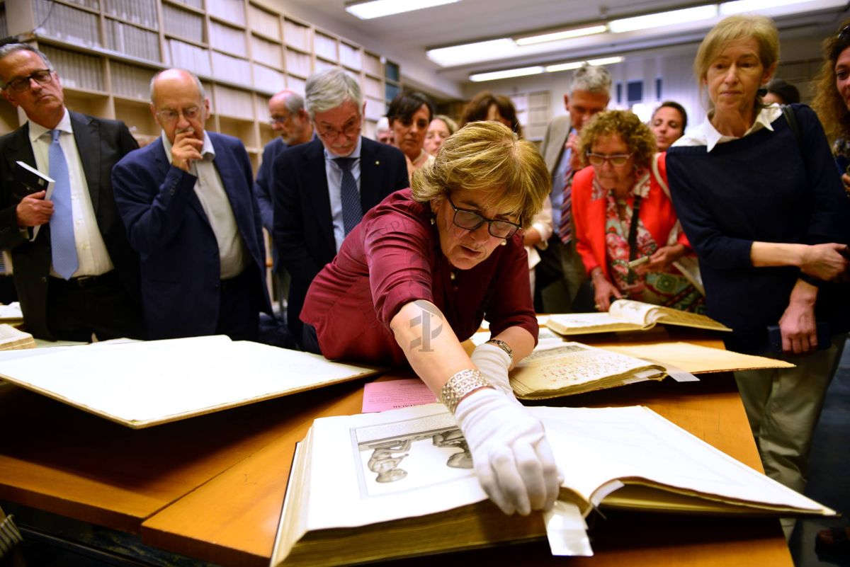 La Dott.ssa Maria Alessandra Falcone, Coordinatrice del Fondo Rari della Biblioteca dell'ISS (in primo piano) illustra agli ospiti alcuni volumi del Fondo Antico. In secondo piano, il Prof. Paolo Bonanni (primo da sinistra), il Prof. Gabriele Pellissero (terzo da sinistra) e la Prof.ssa Annalaura Carducci (quarta da sinistra)