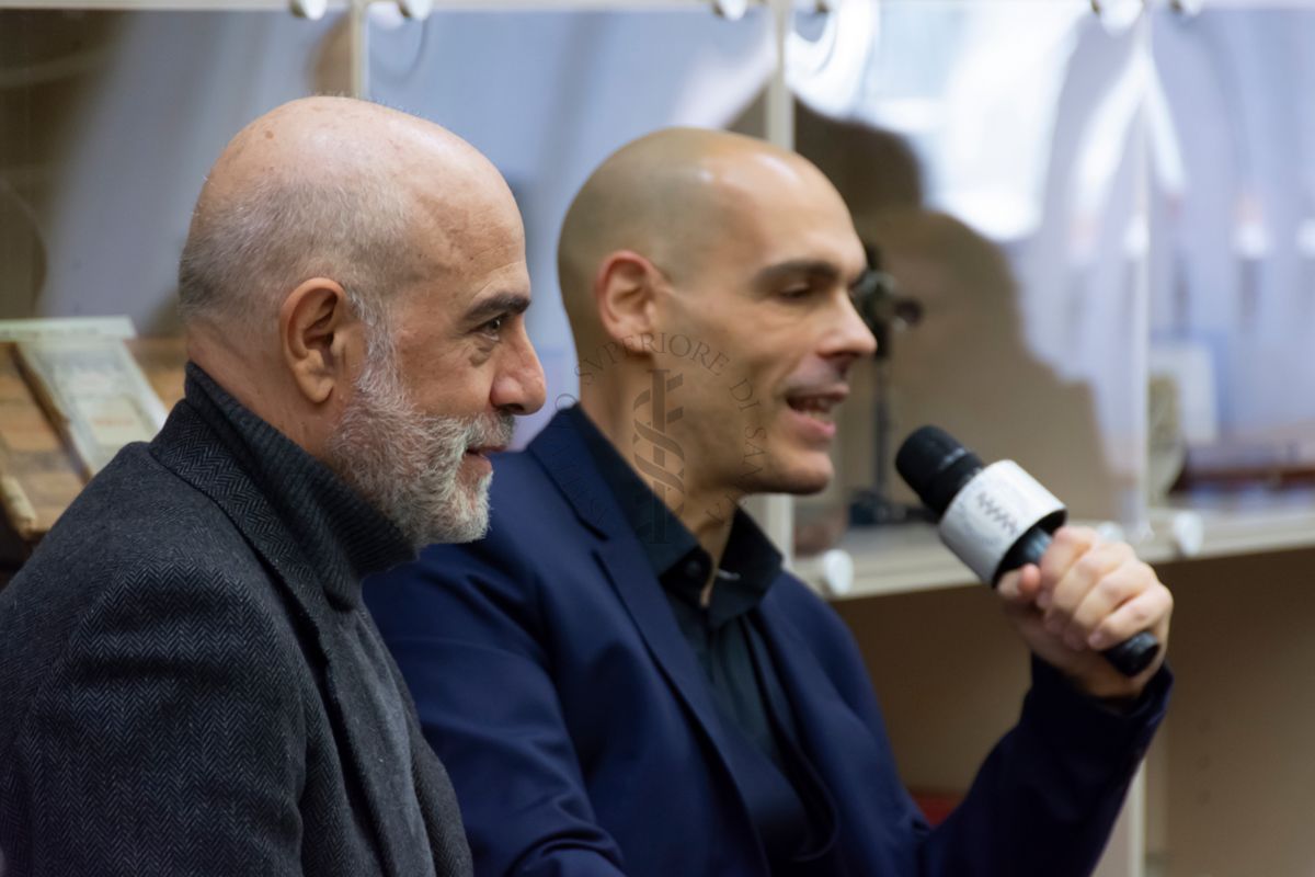 Il Dott. Alessandro Mustazzolu (a destra) risponde alla domanda della ricercatrice. A sinistra il Prof. Antonio Mistretta, Responsabile del Servizio Comunicazione Scientifica dell'ISS