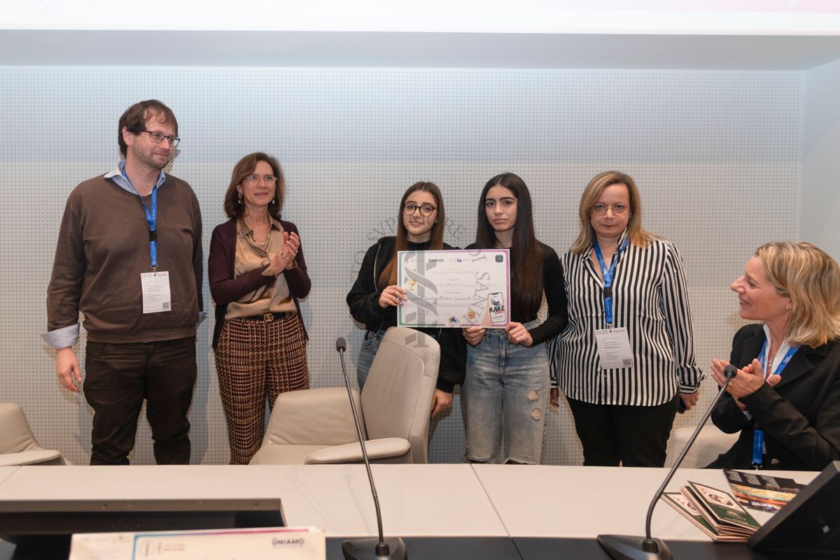 Due ragazze dell'Istituto Comprensivo "Don Diana" di Casal Principe (Caserta) ricevono l'attestato di premiazione "Un giorno da ricercatore all'Istituto Superiore di Sanità". Con loro il Dott. Guido Gigante, ricercatore del Centro Protezione dalle Radiazioni e fisica computazionale dell'Istituto Superiore di Sanità (primo da sinistra), la Dott.ssa. Francesca Cirulli, Direttrice della Ricerca presso il Centro per le Scienze Comportamentali e la Salute Mentale dell'Istituto Superiore di Sanità (seconda da sinistra) e la Dott.ssa Paola Ferrari del Servizio Comunicazione Scientifica, Coordinatrice del Fondo Rari della Biblioteca dell'ISS (sesta da sinistra)
