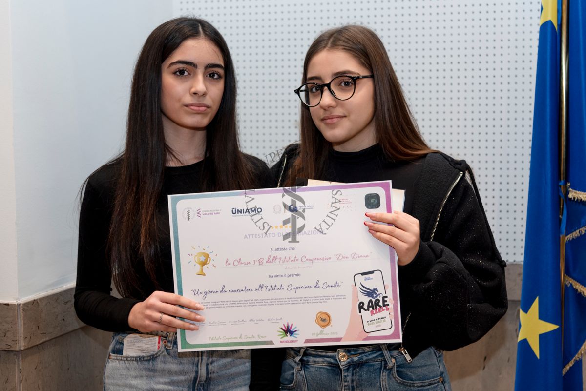 Due ragazze dell'Istituto Comprensivo "Don Diana" di Casal Principe (Caserta) mostrano l'attestato di premiazione "Un giorno da ricercatore all'Istituto Superiore di Sanità"