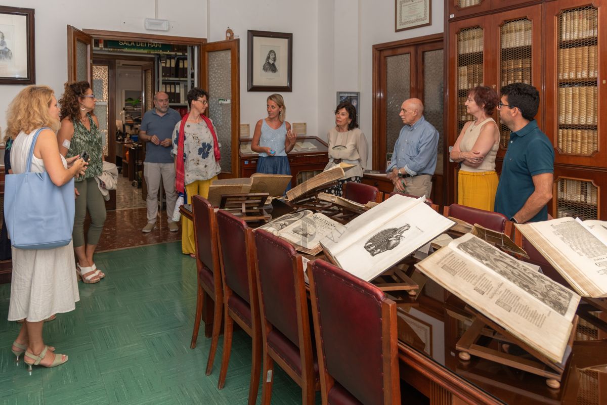 La Dott.ssa Paola Ferrari, Coordinatrice del Fondo Rari della Biblioteca dell'ISS (quinta da sinistra) illustra agli ospiti alcuni volumi del Fondo Antico