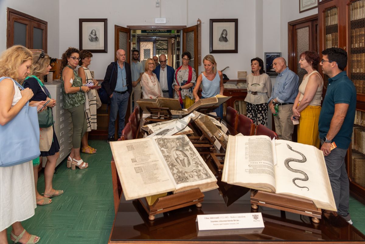 La Dott.ssa Paola Ferrari, Coordinatrice del Fondo Rari della Biblioteca dell'ISS (undicesima da sinistra) illustra agli ospiti alcuni volumi del Fondo Antico.Quinto da sinistra il Prof. Giovanni Rezza, ex Dirigente dell'ISS e ex Direttore generale della Prevenzione Sanitaria del Ministero della Salute e nono da sinistra il Prof. Antonio Mistretta, Responsabile del Servizio Comunicazione Scientifica dell'ISS