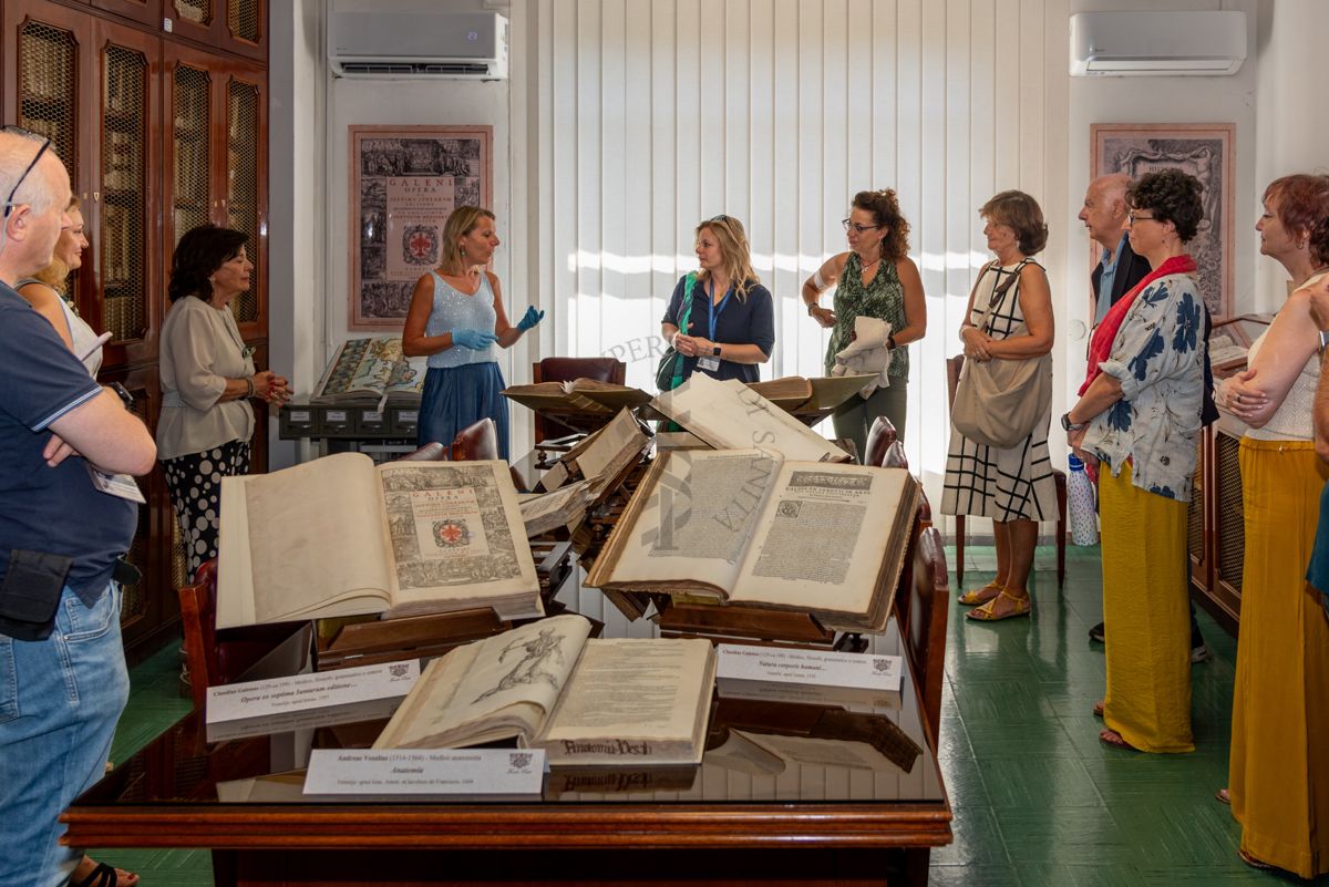 La Dott.ssa Paola Ferrari, Coordinatrice del Fondo Rari della Biblioteca dell'ISS (quarta da sinistra) illustra agli ospiti alcuni volumi del Fondo Antico