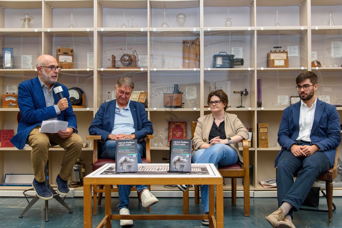 Il Prof. Antonio Mistretta, Responsabile del Servizio Comunicazione Scientifica dell'ISS (a sinistra) presenta il libro "Guida facile all'intelligenza artificiale in medicina". Accanto il Dott. Alberto Eugenio Tozzi, Responsabile di Unità di Ricerca Medicina Predittiva e Preventiva presso l'Ospedale Pediatrico Bambino Gesù di Roma, la Dott.ssa Diana Ferro, biologa, ricercatrice e health data scientist presso l'Ospedale Pediatrico Bambino Gesù di Roma (terza da sinistra) e il Dott. Luigi de Angelis, medico e Presidente della Società Italiana Intelligenza Artificiale in Medicina (quarto da sinistra)