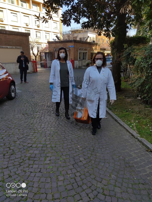 Eleonora Benedetti e Concetta Fabiani, del gruppo organizzato per l'Emergenza Covid, Dipartimento Malattie Infettive (DMI) ricevono i tamponi da analizzare nel cortile dell'Istituto Superiore di Sanità