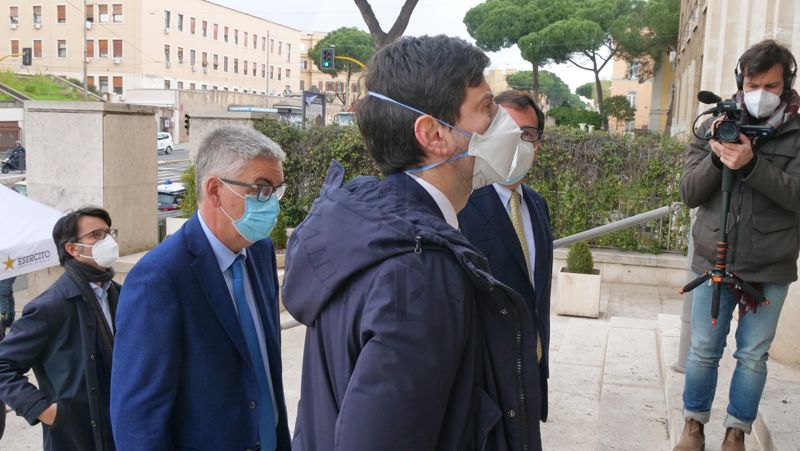 Il Ministro della Salute Roberto Speranza (in primo piano) osserva i danni causati dall'atto incendiario al portone dell'Istituto Superiore di Sanità. In secondo piano, il Presidente Silvio Brusaferro (a sinistra) e il Direttore Generale Andrea Piccioli (a destra, leggermente coperto)