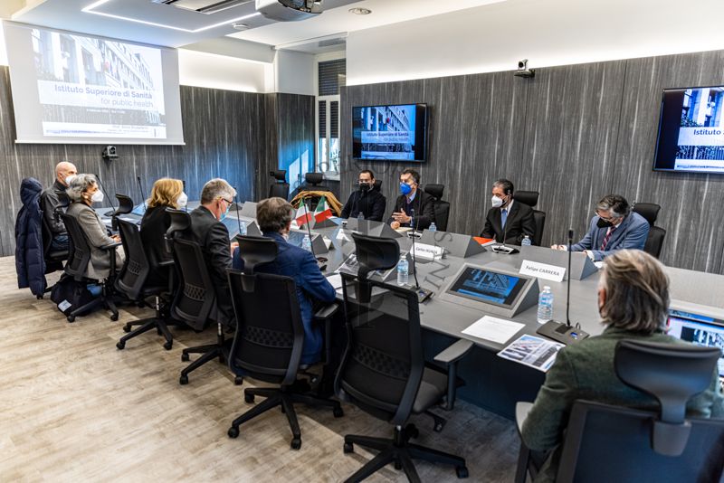 Riunione in Sala Crisi dell'ISS, di spalle, partendo da sinistra: il Prof. Angelo Picardi, ricercatore del Centro di Riferimento per le Scienze Comportamentali e la Salute Mentale dell'ISS; la Dr.ssa Maria Antonietta Stazi, direttrice del Reparto di Ricerca clinico-epidemiologica in salute mentale e comportamentale dell'ISS; la Dr.ssa Gemma Calamandrei, direttrice del Centro di riferimento per le scienze comportamentali e la salute mentale; Il Prof. Silvio Brusaferro, Presidente dell'ISS; il Dr. Luigi Bertinato, responsabile della segreteria scientifica di presidenza dell'ISS; il Dr. Marco Simonelli del Centro Nazionale Salute Globale. Frontalmente, partendo da sinistra: il Dr. Miguel Álvaro Pérez Hernández; il Dr.Carlos Eugenio García de Alba Zepeda, Ambasciatore del Messico;  il Dr. Carlos Jesus Isunza Chavez, primo segretario dell'Ufficio affari e promozione economico-commerciali dell'Ambasciata del Messico; il Dr. Felipe Carrera Aguayo, Console del Messico in Italia