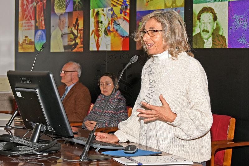 Intervento della Dott.ssa Paola De Castro, Responsabile del Servizio Comunicazione Scientifica dell'Istituto Superiore di Sanità. In secondo piano il Dott. Franco Toni, Direttore della Biblioteca dell'Istituto Superiore di Sanità (primo da sinistra) e la Dott.ssa Elisabetta Poltronieri del Servizio Comunicazione Scientifica dell'Istituto Superiore di Sanità (seconda da sinistra)