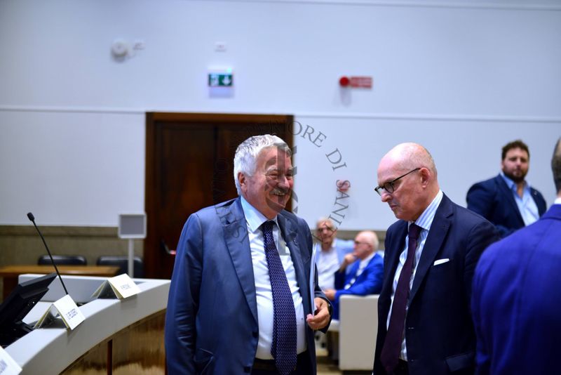 Scambio di saluti tra il Presidente dell'Istituto Superiore di Sanità, Prof. Rocco Bellantone (a sinistra) e il Prof. Walter Ricciardi (al centro), Presidente del Mission Board for Cancer della Commissione Europea e della World Federation of Public Health Associations ed ex Presidente dell'Istituto Superiore di Sanità