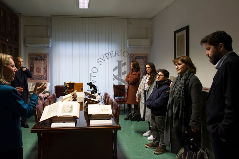 Prima della presentazione del libro "Non è mai morto nessuno" del Dott. Alessandro Mustazzolu (secondo da sinistra), la Dott.ssa Paola Ferrari, Coordinatrice del Fondo Rari della Biblioteca dell'ISS (prima da sinistra) illustra agli ospiti alcuni volumi del Fondo Antico e alcuni strumenti scientifici