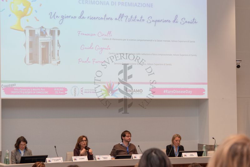 La Dott.ssa. Francesca Cirulli, Direttrice della Ricerca presso il Centro per le Scienze Comportamentali e la Salute Mentale dell'Istituto Superiore di Sanità (seconda da sinistra) illustra uno dei punti del programma della giornata: "Un giorno da ricercatore all'Istituto Superiore di Sanità". Con lei il Dott. Guido Gigante, ricercatore del Centro Protezione dalle Radiazioni e fisica computazionale dell'Istituto Superiore di Sanità (terzo da sinistra) e la Dott.ssa Paola Ferrari del Servizio Comunicazione Scientifica, Coordinatrice del Fondo Rari della Biblioteca dell'ISS (quarta da sinistra)