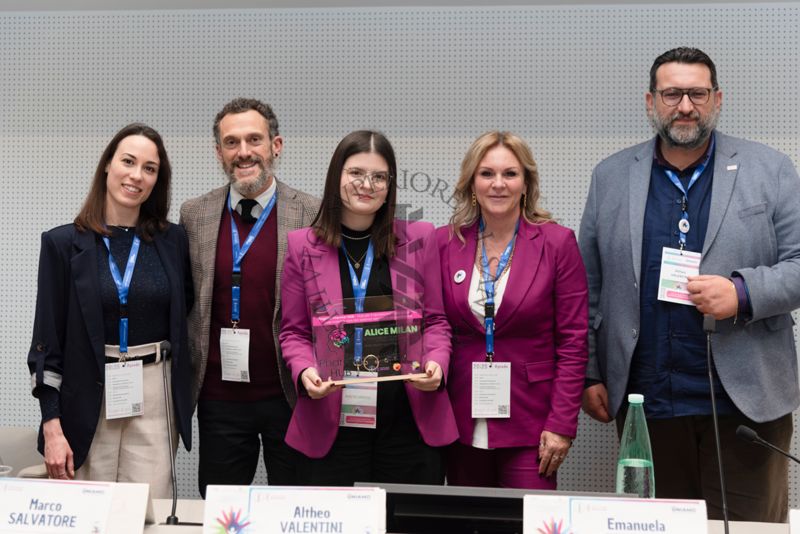 La premiazione di Alice Milan (terza da sinistra), vincitrice del Pharma-HUB Project's Logo and Visual Identity International Contest!. Con lei la Dott.ssa Lucrezia Micheli del progetto Pharma-HUB dell'ISS (prima da sinistra), il Dott. Marco Salvatore, responsabile scientifico Pharma-HUB dell'SS (secondo da sinistra), la Prof.ssa Emanuela Esposito, Coordinatrice del Progetto Pharma-HUB dell'Università di Messina (quarta da sinistra) e il giornalista Altheo Valentini, Project Manager nel campo dei finanziamenti europei e nell'innovazione digitale e sociale e fondatore della European Grants International Academy Srl (quinto da sinistra)