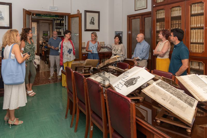 La Dott.ssa Paola Ferrari, Coordinatrice del Fondo Rari della Biblioteca dell'ISS (quinta da sinistra) illustra agli ospiti alcuni volumi del Fondo Antico