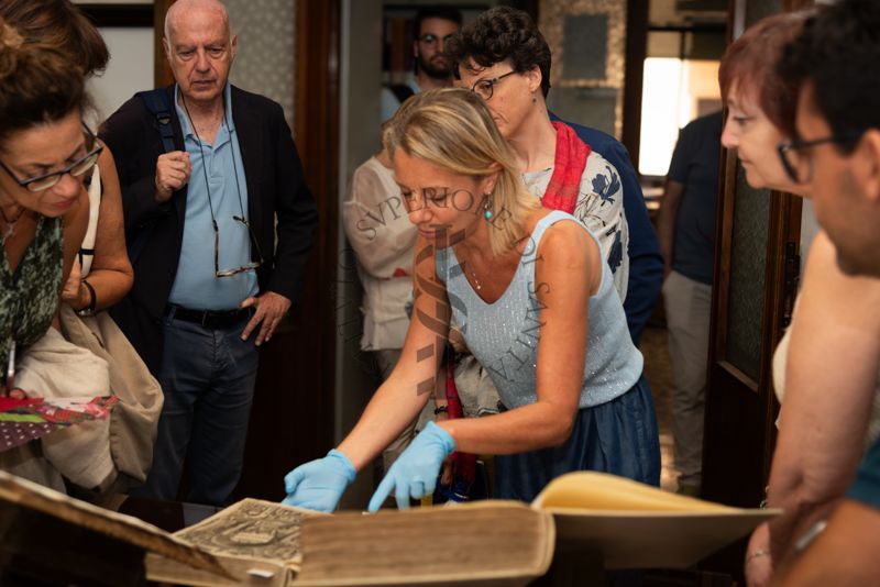 La Dott.ssa Paola Ferrari, Coordinatrice del Fondo Rari della Biblioteca dell'ISS (al centro) illustra agli ospiti alcuni volumi del Fondo Antico. Secondo da sinistra il Prof. Giovanni Rezza, ex dirigente dell'ISS e ex direttore generale della Prevenzione sanitaria del Ministero della Salute