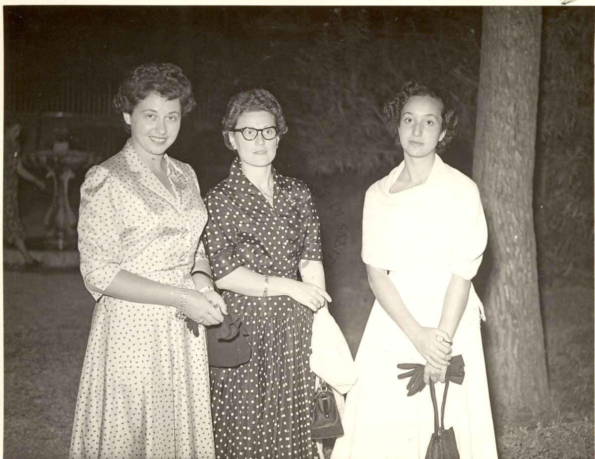 Foto di tre donne in posa durante il ricevimento offerto dall'Istituto Superiore di Sanità nel giardino in occasione del congresso