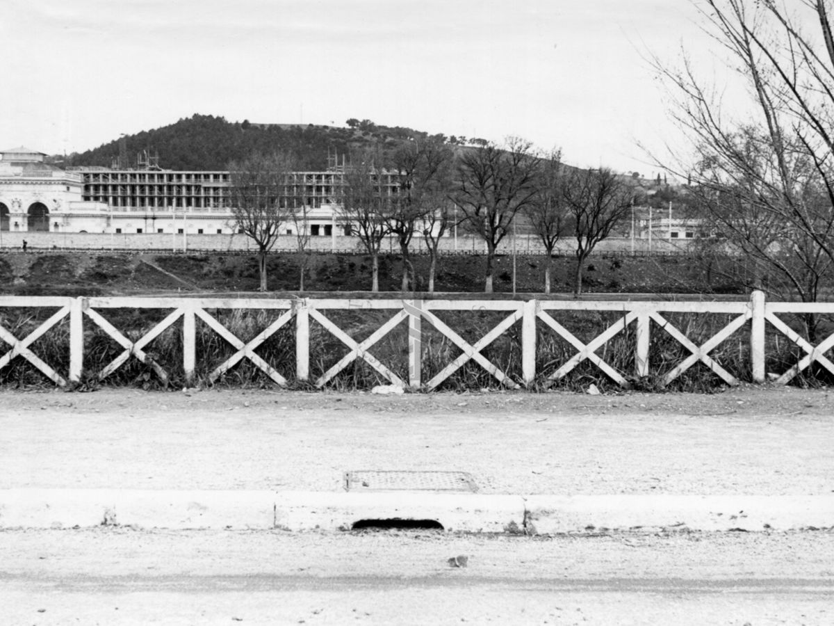 Inquadratura del marciapiede di una carreggiata che corre parallela al Tevere, con il Palazzo Littorio in costruzione sullo sfondo