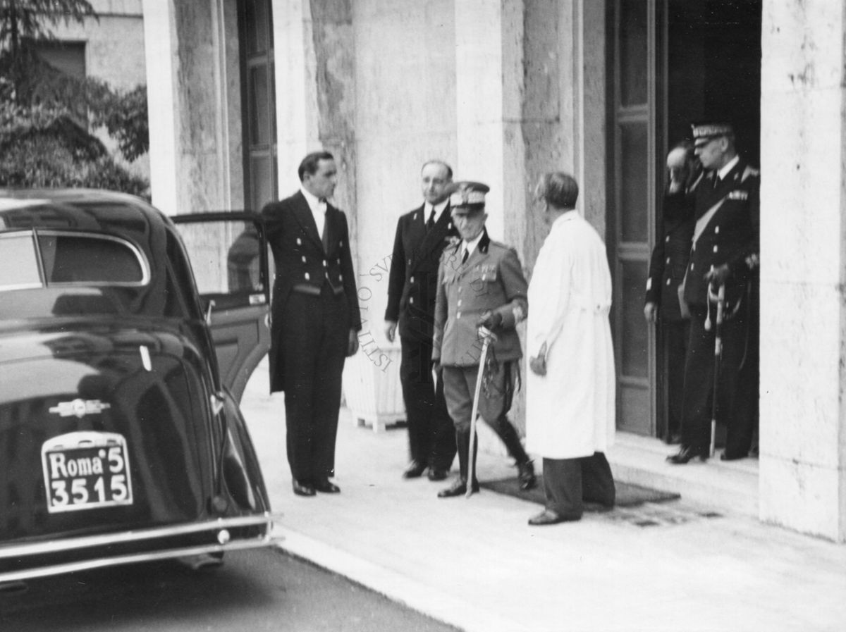 Vittorio Emanuele III, in visita all'Istituto di Sanità Pubblica, esce dall'Istituto per risalire in macchina; alle sue spalle, a sinistra, il Prof. Domenico Marotta
