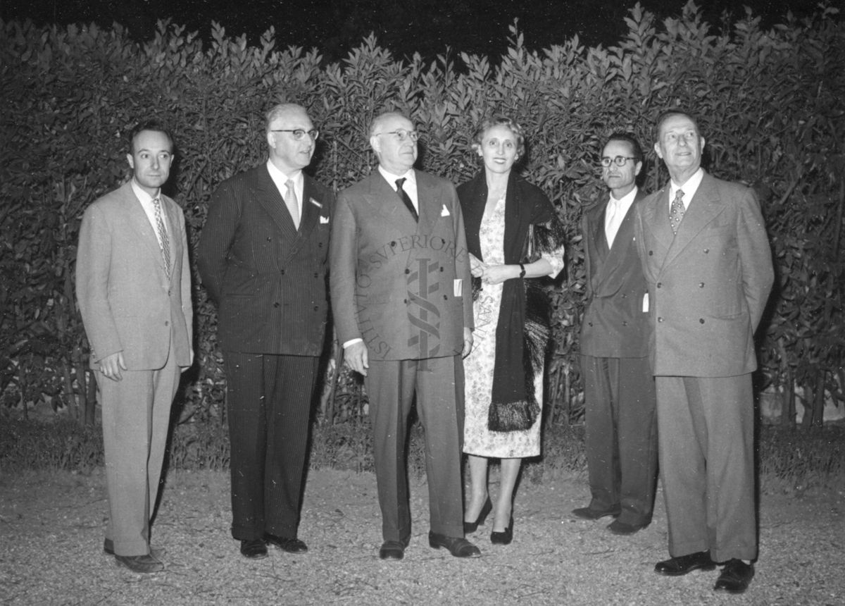 Foto di gruppo di alcuni di cinque uomini e una donna partecipanti al ricevimento tenuto nei giardini dell'Istituto Superiore di Sanità in occasione del Congresso internazionale di terapia medica.