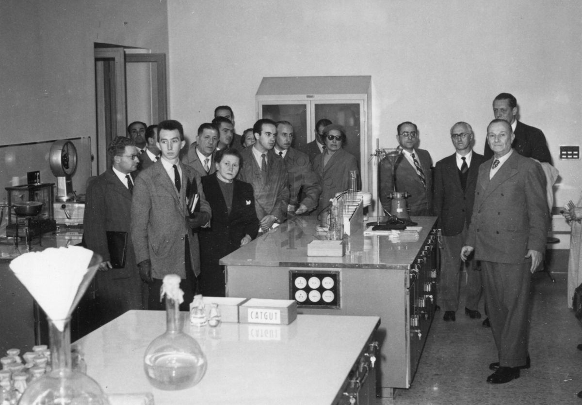 Il gruppo dei partecipanti all'VIII Congresso di cinematografia scientifica disposto intorno ai banconi di uno dei laboratori dell'Istituto Superiore di Sanità. Presente il Dott. Massimo Pantaleoni (in primo piano a destra)