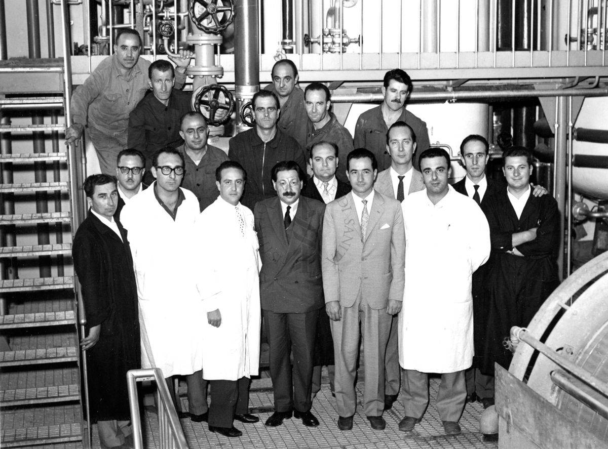 Foto di gruppo con al centro il Prof. Ernst Boris Chain, all'interno dell'edificio che ospitava i fermentatori per la fabbricazione della penicillina