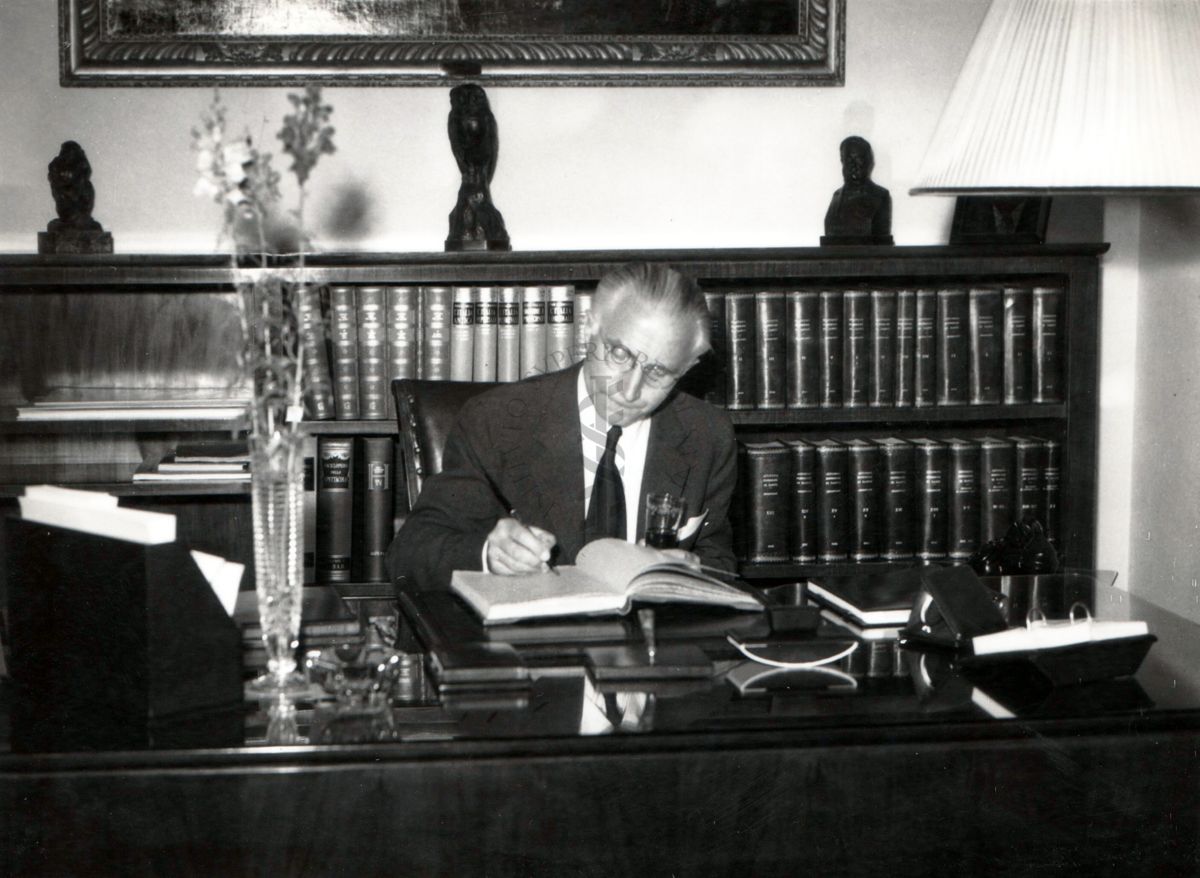 Il prof. Mann seduto alla scrivania del prof. Domenico Marotta nella sala della presidenza.