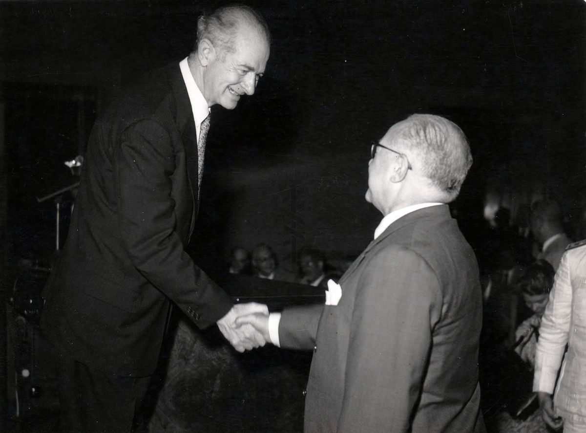 Il prof. Linus Carl Pauling (lato sinistro della foto) stringe la mano al prof. Domenico Marotta (lato destro della foto) nell'aula magna dell'Istituto Superiore di Sanità.