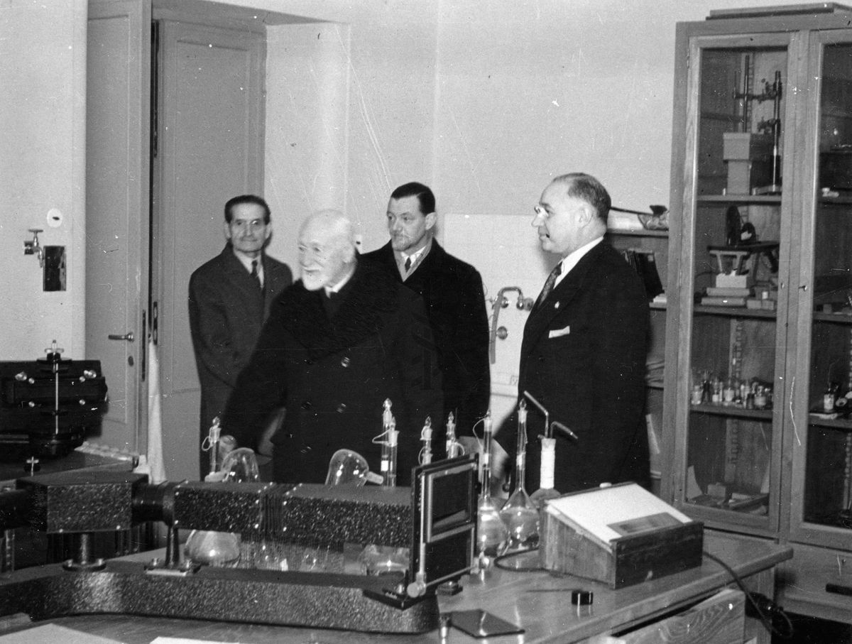Il prof. Domenico Marotta (primo a destra) illustra un laboratorio dell'Istituto Superiore di Sanità al principe Ludovico Chigi della Rovere Albani (posizionato davanti a tutti). Nella foto sono presenti altre due persone non identificate sul fondo.