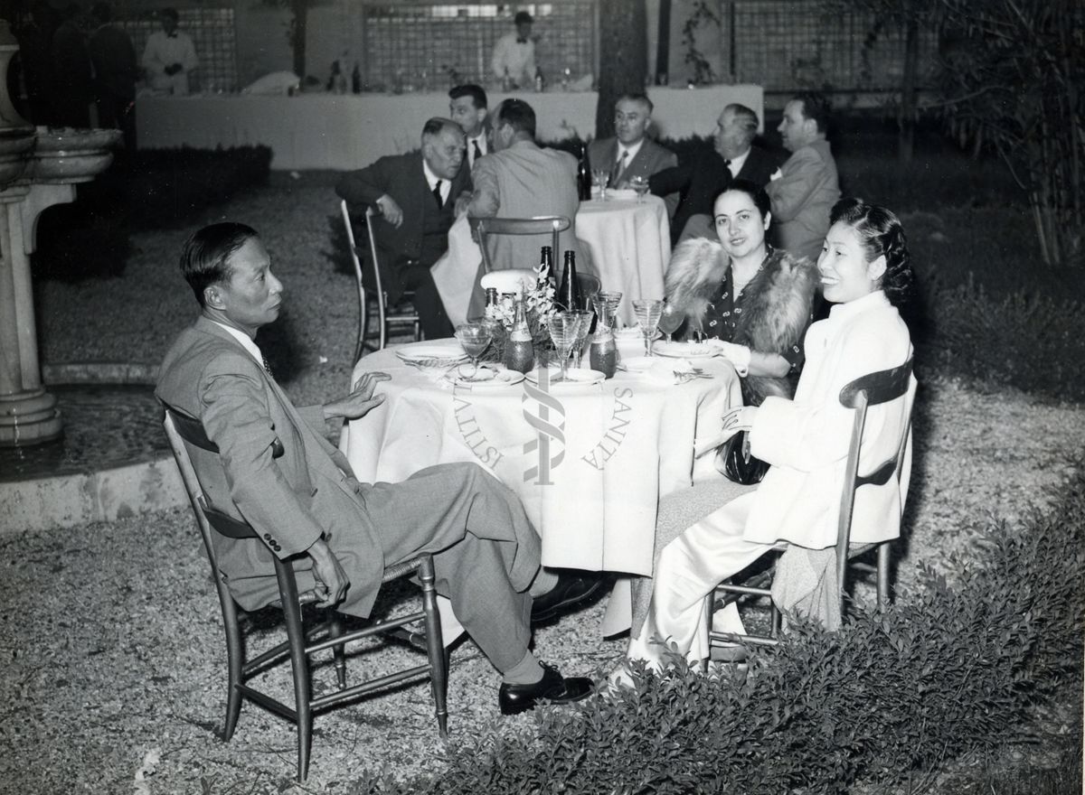 Foto dei presenti seduti a due dei tavoli allestiti nel giardino dell'Istituto Superiore di Sanità in occasione del IX Congresso internazionale dell'industria agraria