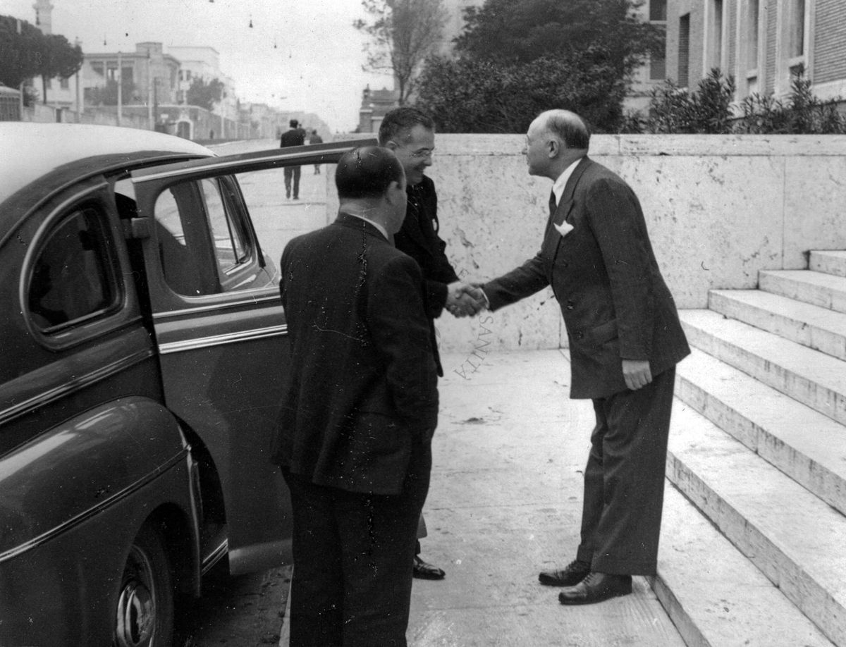 Il prof. D. Marotta (primo sulla destra) saluta tendendo la mano all'Avv. Marchisi (prima di entrare in macchina).
