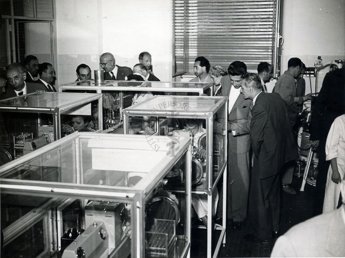 Il gruppo dei Deputati in visita all'Istituto Superiore di Sanità ripresi  all'interno di uno dei laboratori dell'Istituto intorno a dei macchinari