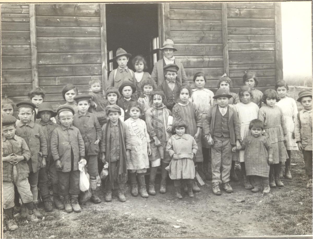 Gruppo di bambini malarici fotografati davanti una baracca-scuola.