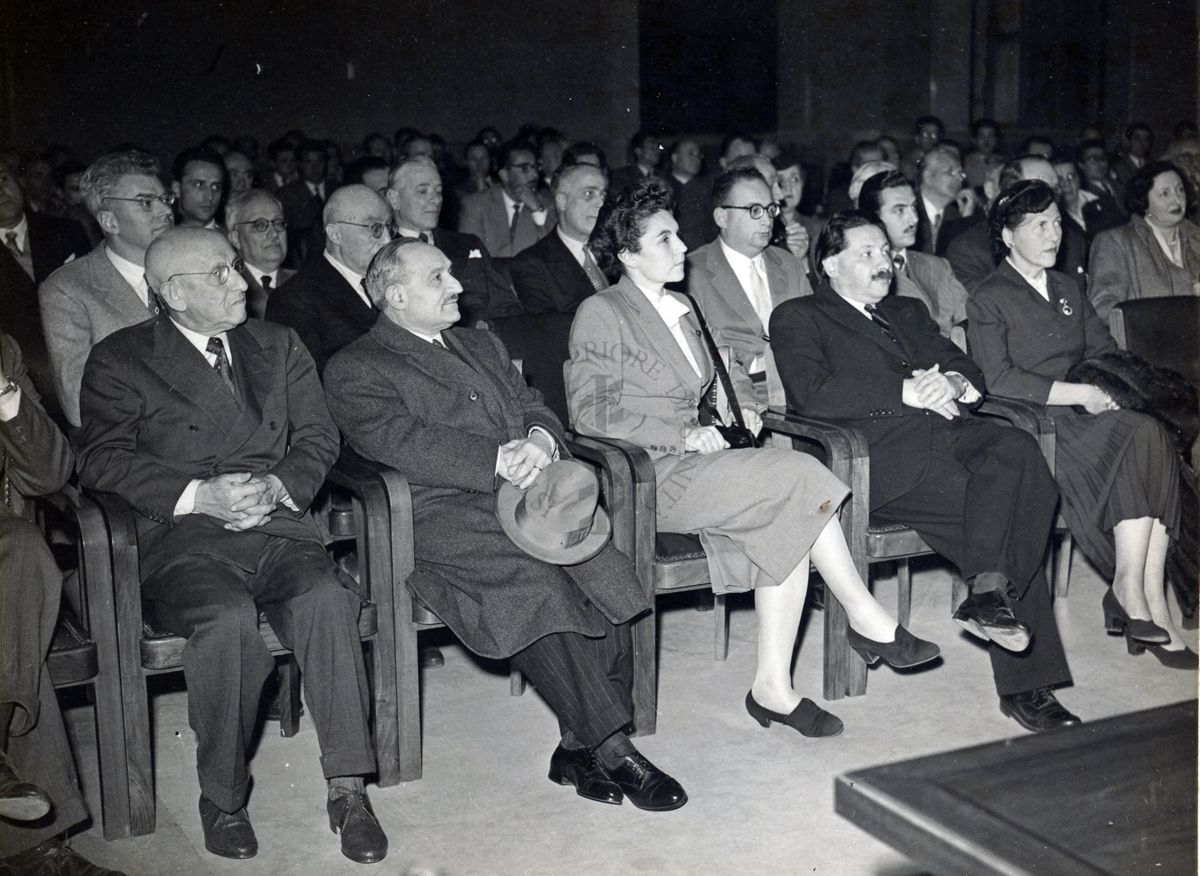 Parte dell'uditorio presente in aula magna in occasione della conferenza tenuta dal Prof. H. Corwin Hinshaw all'Istituto Superiore di Sanità. In prima fila: il Prof. Ernst Boris Chain (secondo da destra) e la Dr.ssa Anne Beloff-Chain (terza da destra). In seconda fila: il Prof. Giovanni Battista Marini Bettolo (primo da sinistra).