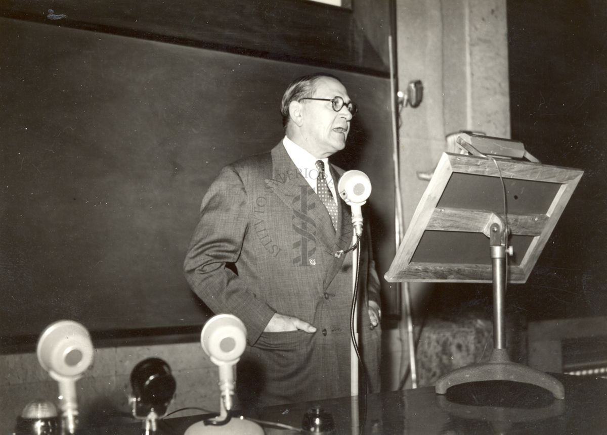 Il Prof. Windeyer in piedi, dietro alla cattedra dell'aula magna, in occasione della conferenza tenuta all'Istituto Superiore di Sanità