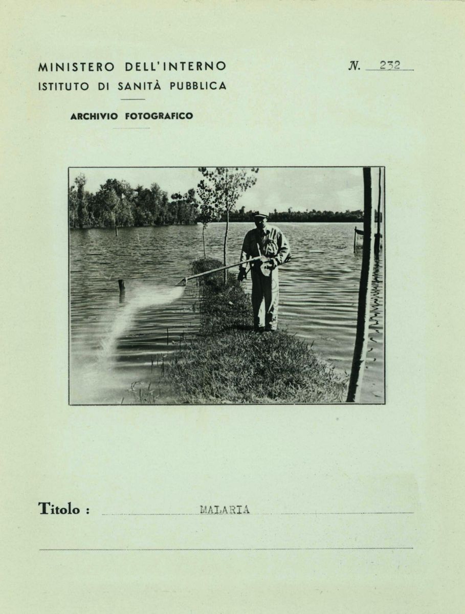 Riproduzione di una scheda di catalogazione fotografica (lato A). Descrizione: "Ministero dell'Interno - Istituto di Sanità Pubblica - Archivio Fotografico (alto SX)"; "N. 232 (alto DX)"; "Foto in campo medio di un    uomo che sparge il Verde di Parigi nel lago di Isoletta del Liri al centro della scheda)"; "Titolo: MALARIA" in basso al centro