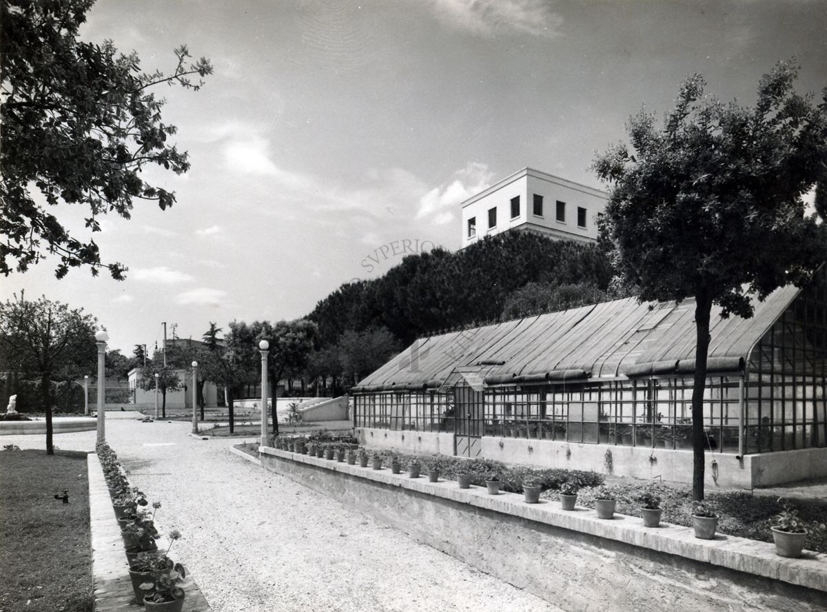 Immagine del viale di un giardino (con la serra) dell'Istituto Superiore di Sanità