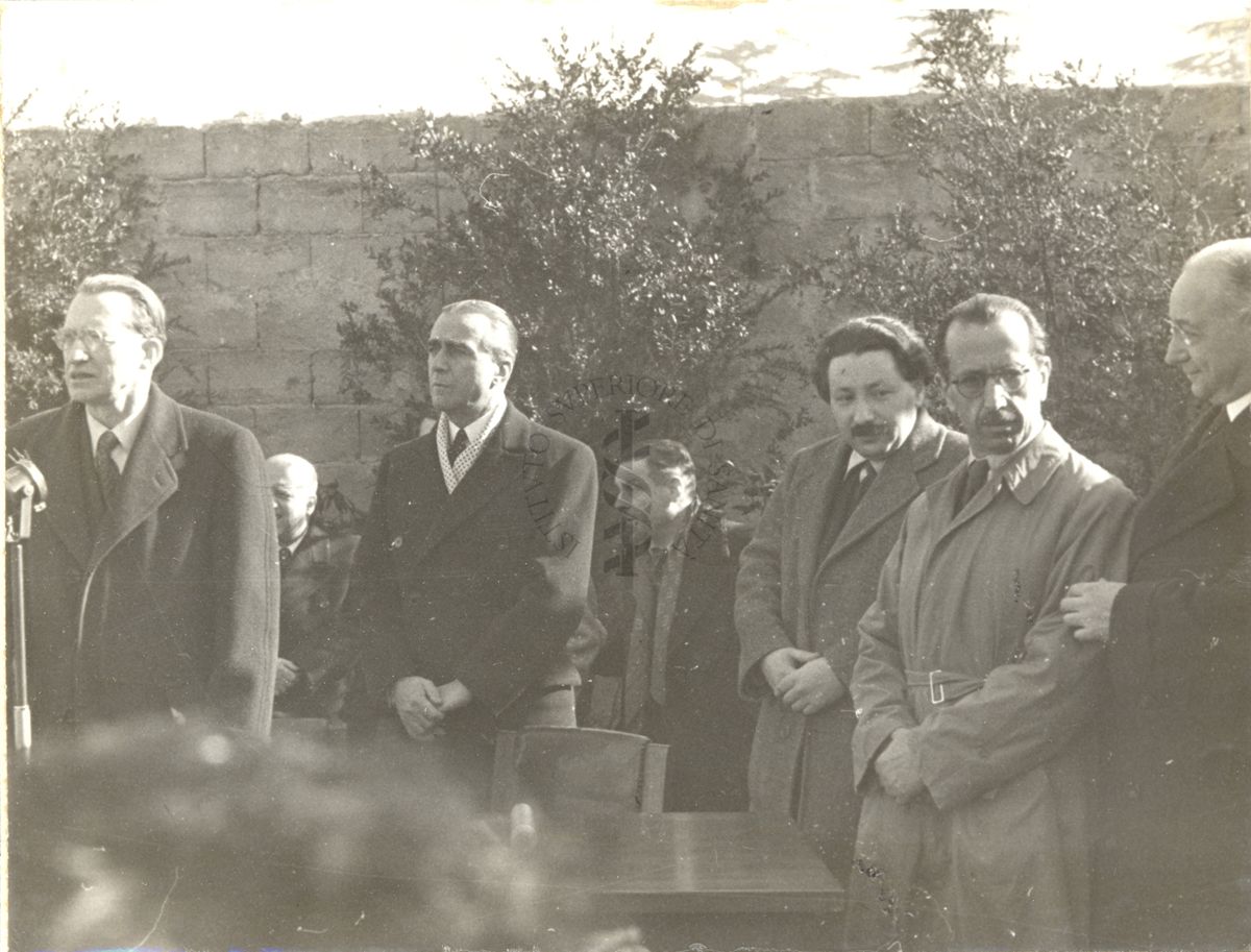 Cerimonia della posa della prima pietra per l'erigendo Istituto della Penicillina. Parla il Presidente del Consiglio on. Alcide de Gasperi, dietro di lui l'Ambasciatore d'America James Clement Dunn, alla sua sinistra il premio Nobel per la medicina e la fisiologia Ernst Boris Chain, segue il prof. Nicola Perotti Alto Commissario per l'Igiene e la Sanità Pubblica, infine il prof. Domenico Marotta