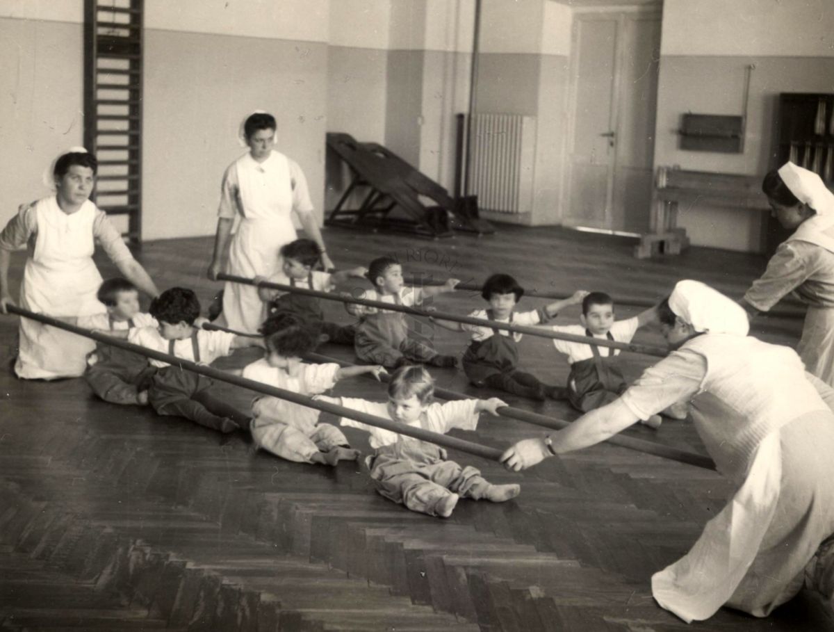 Sala per la ginnastica collettiva dell'Istituto Ortopedico "Luigi Spolverini" di Ariccia (Roma) - delle infermiere sorreggono alcune aste per guidare i movimenti dei bambini