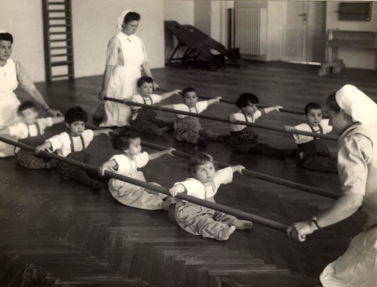 Sala per la ginnastica collettiva dell'Istituto Ortopedico "Luigi Spolverini" di Ariccia (Roma) - delle infermiere sorreggono alcune aste per guidare i movimenti dei bambini