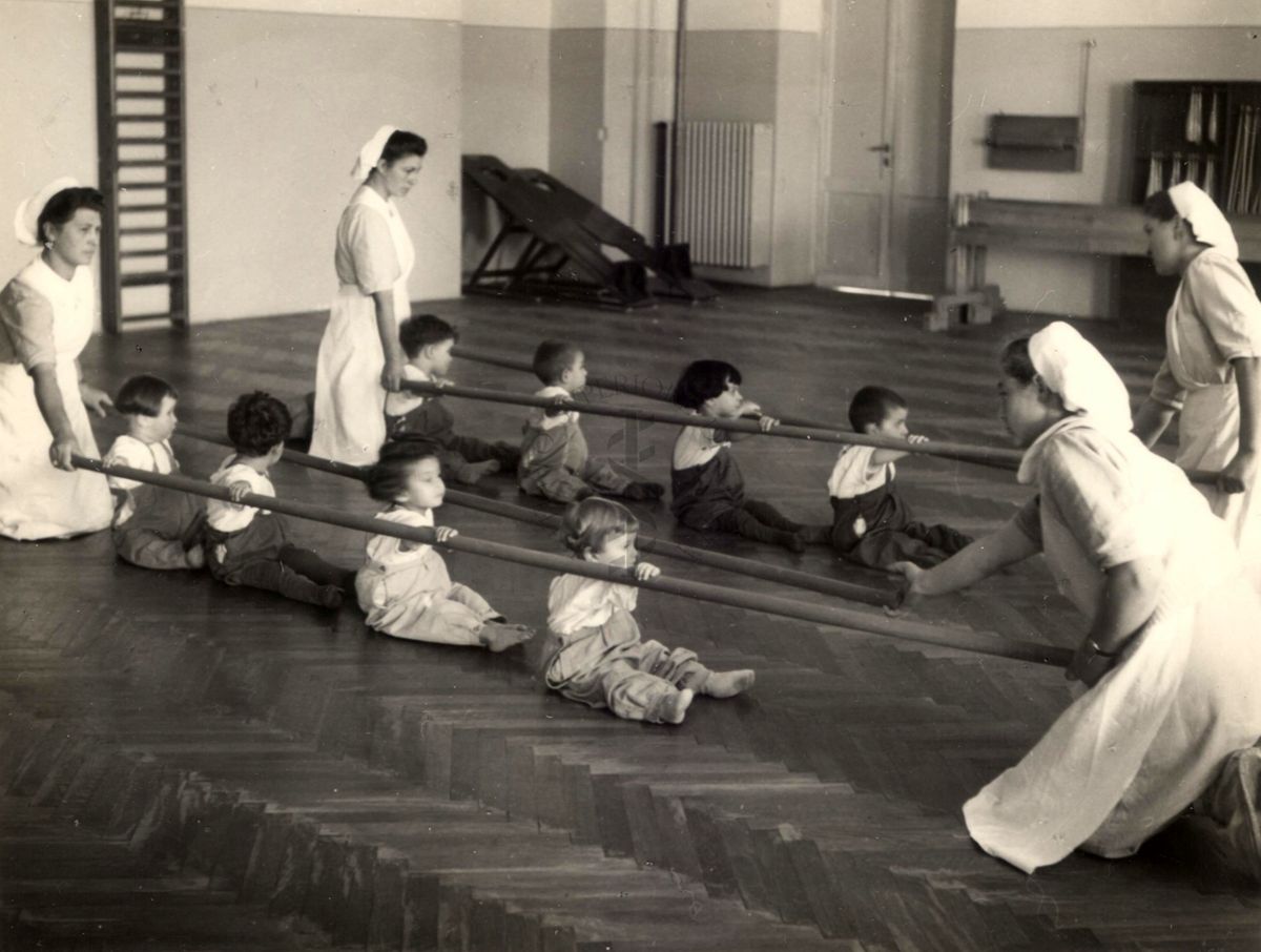 Sala per la ginnastica collettiva dell'Istituto Ortopedico "Luigi Spolverini" di Ariccia (Roma) - delle infermiere sorreggono alcune aste per guidare i movimenti dei bambini