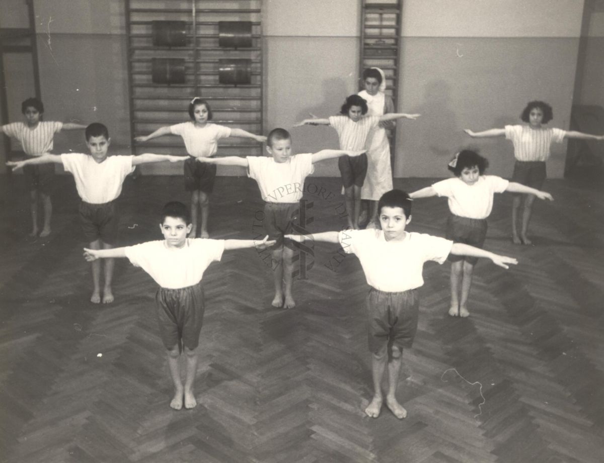 Sala per la ginnastica collettiva dell'Istituto Ortopedico "Luigi Spolverini" di Ariccia (Roma) - un'infermiera controlla la postura di un gruppo di bambini che svolgono esercizi ginnici