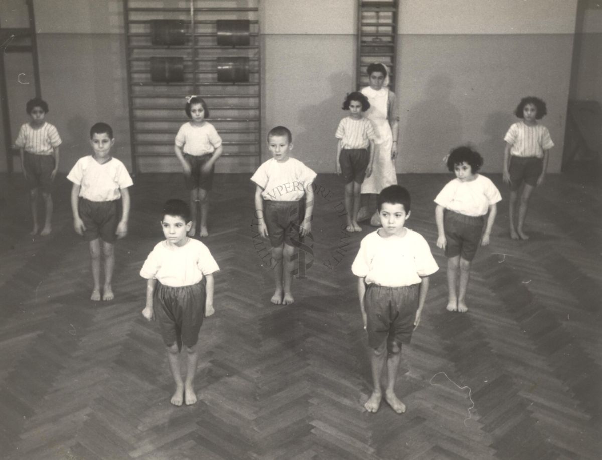 Sala per la ginnastica collettiva dell'Istituto Ortopedico "Luigi Spolverini" di Ariccia (Roma) - un'infermiera controlla la postura di un gruppo di bambini che svolgono esercizi ginnici