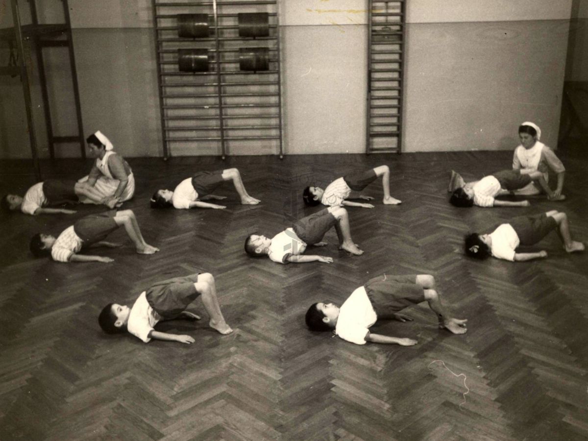 Sala per la ginnastica collettiva dell'Istituto Ortopedico "Luigi Spolverini" di Ariccia (Roma) - delle infermiere controllano la postura di un gruppo di bambini che svolgono esercizi ginnici