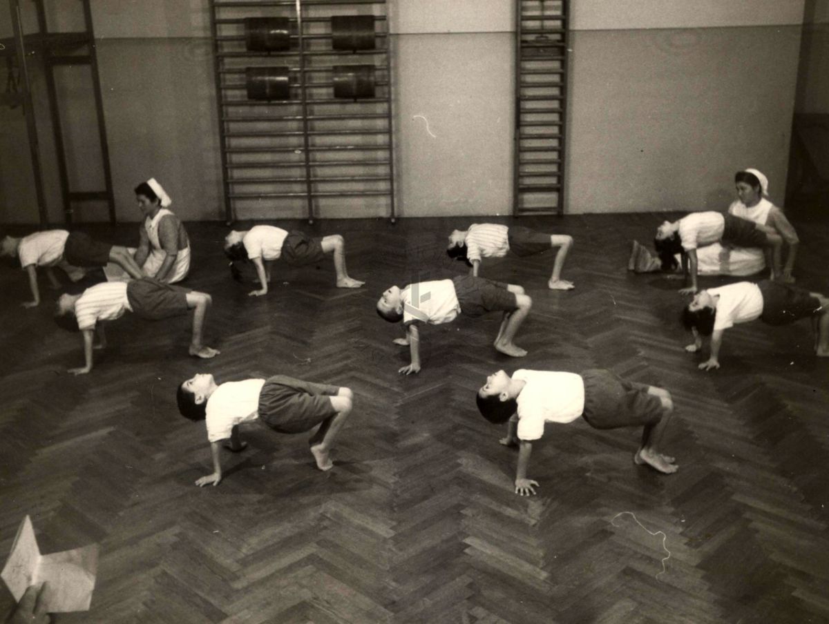 Sala per la ginnastica collettiva dell'Istituto Ortopedico "Luigi Spolverini" di Ariccia (Roma) - delle infermiere controllano la postura di un gruppo di bambini che svolgono esercizi ginnici