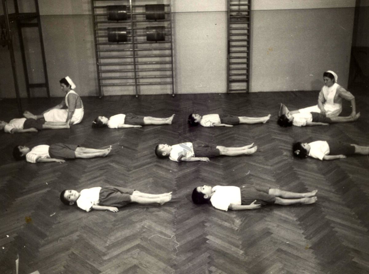 Sala per la ginnastica collettiva dell'Istituto Ortopedico "Luigi Spolverini" di Ariccia (Roma) - delle infermiere controllano la postura di un gruppo di bambini che svolgono esercizi ginnici