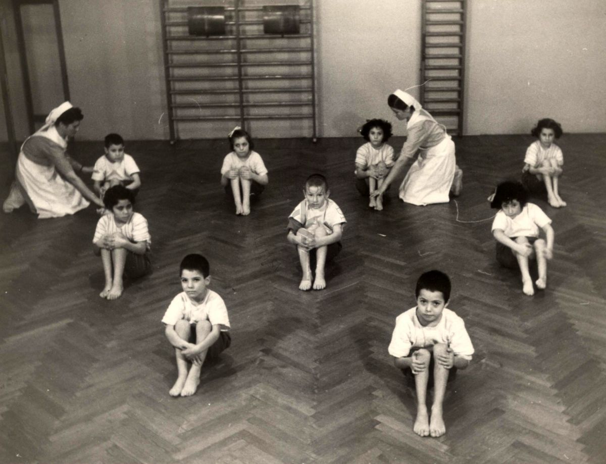 Sala per la ginnastica collettiva dell'Istituto Ortopedico "Luigi Spolverini" di Ariccia (Roma) - delle infermiere controllano la postura di un gruppo di bambini che svolgono esercizi ginnici