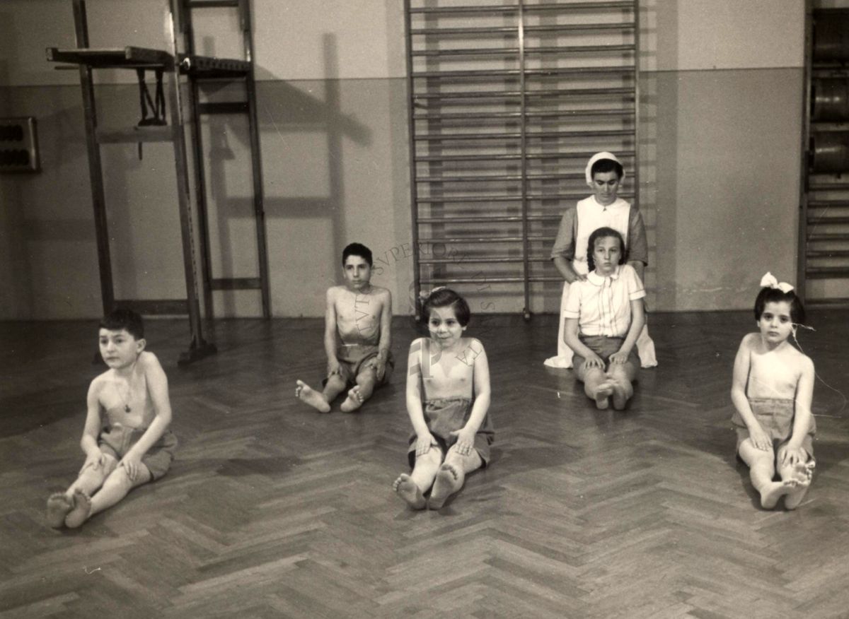 Istituto Ortopedico "Luigi Spolverini" di Ariccia - Bambini che effettuano ginnastica segmentaria per la spalla seguiti da assistenti